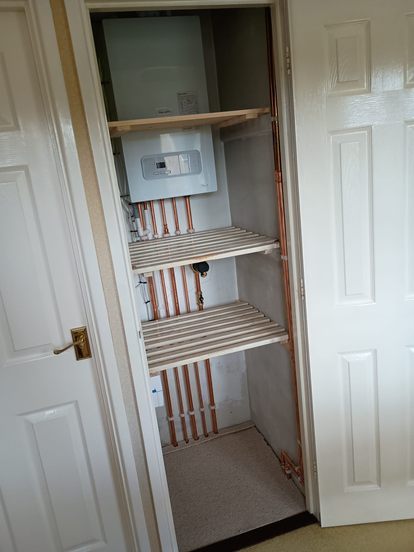 New combi boiler installed in an airing cupboard with copper pipework